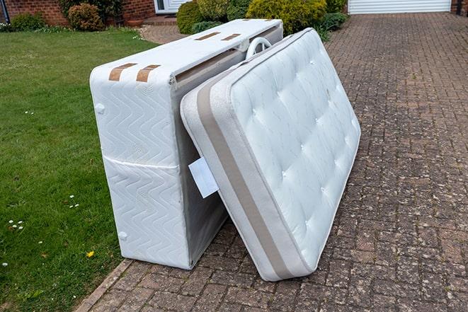 a mattress being loaded onto a truck for pickup and disposal